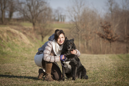 年轻女子和狗狗在田里的肖像家养狗高清图片素材