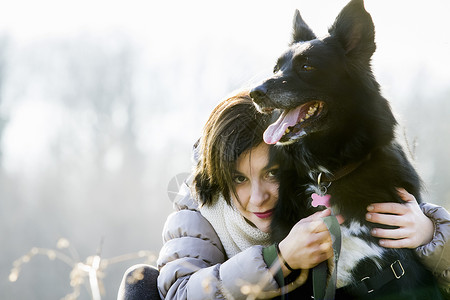 抱着狗狗的年轻女性肖像无忧无虑的高清图片素材