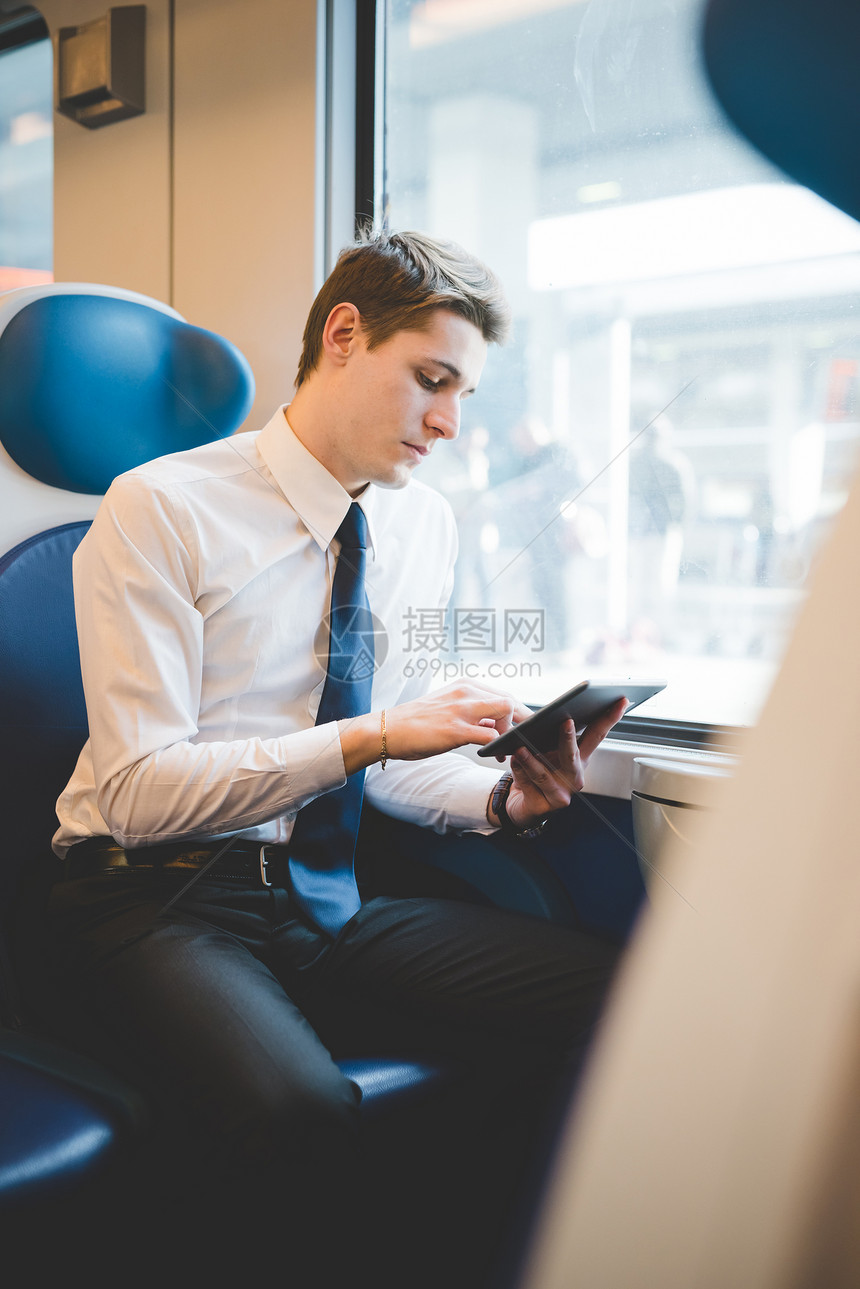 在火车上使用数字平板电脑的青年图片