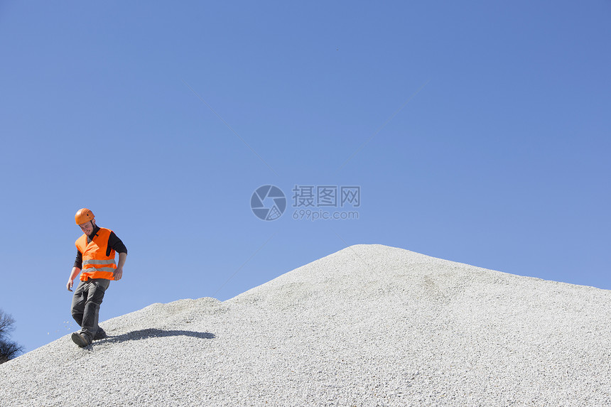 采石场的工人在陡峭的碎石堆移动图片