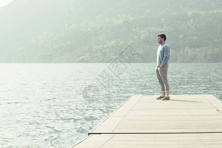湖边码头上欣赏风景的男子高清图片