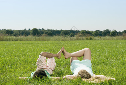 男孩和女孩平躺在草地上看着天空图片