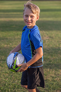 男孩在足球练习场上踢足球图片