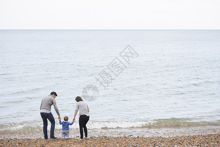 年轻家庭在石子海滩上行走图片