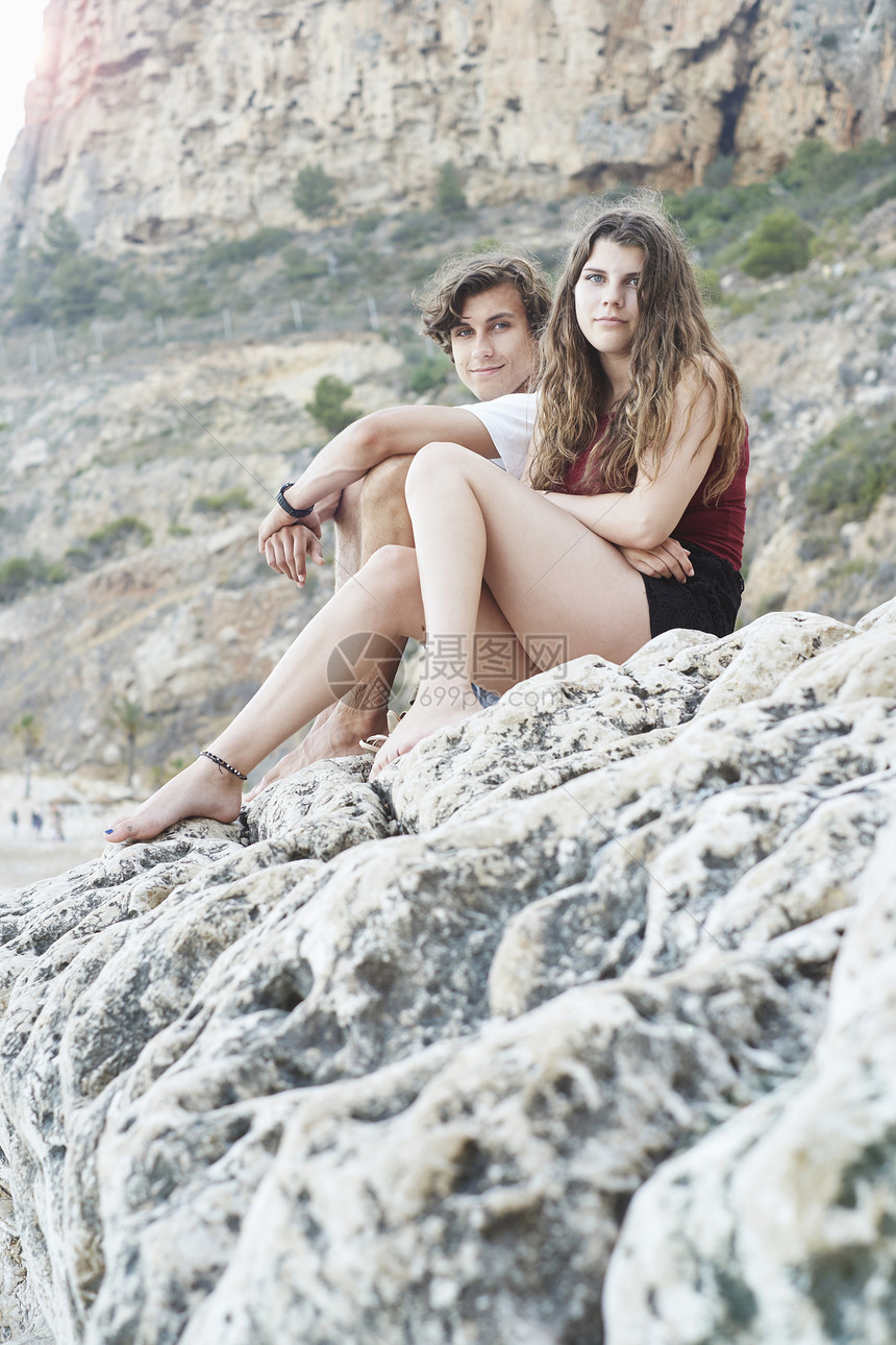 西班牙贾韦亚岩石海滩上年轻男子和十几岁的姐妹肖像图片