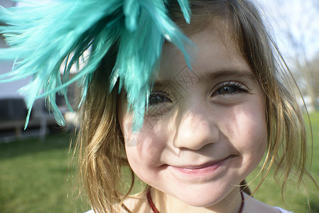 小女孩带着羽毛在头上愉快高清图片素材