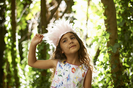 在森林里穿羽毛的漂亮女孩肖像土耳其人高清图片素材