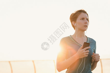 年中成妇女戴耳机户外健身图片