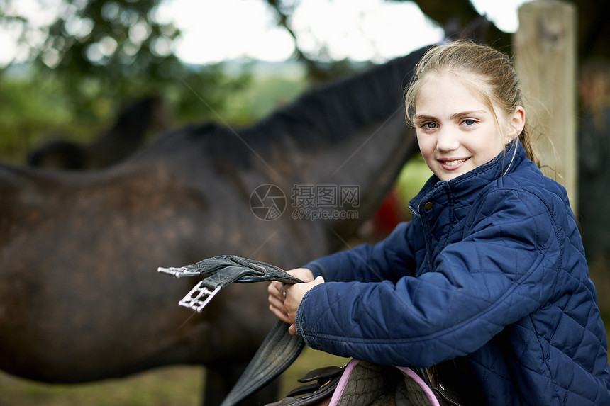 整理马鞍的女童骑士图片