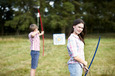少女与兄弟一起射箭背景图片
