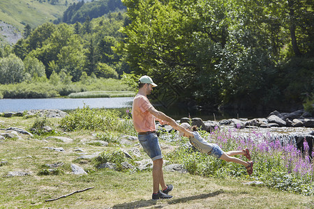 父亲和女儿在溪流上玩得开心图片