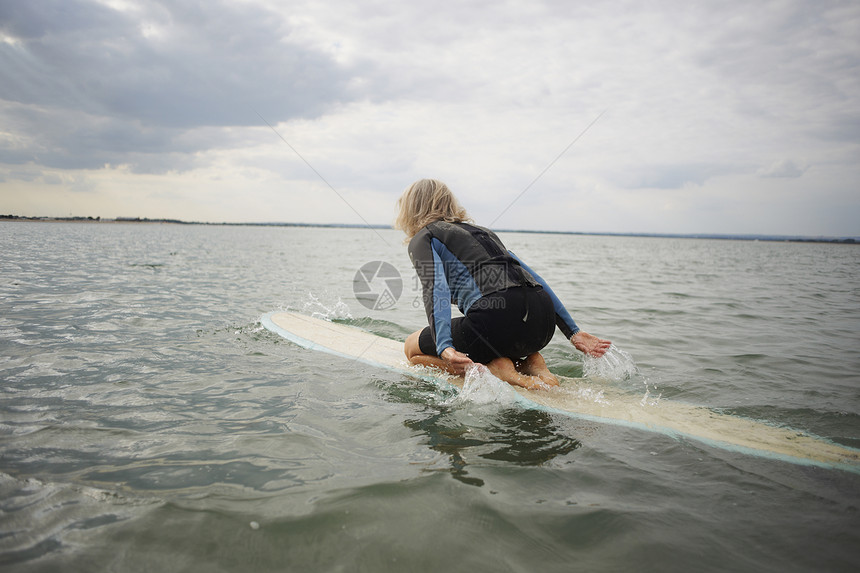 中老年女性在海上的冲浪板划桨图片