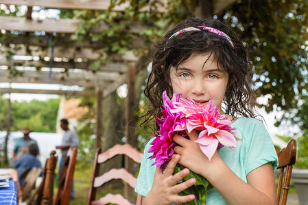 小女孩在户外拿着鲜花的肖像图片