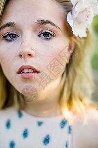 近身肖像年轻女子的鼻头发花朵看着镜头图片