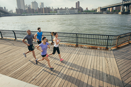 四位成年跑步者沿河边布鲁克林纽约美国图片
