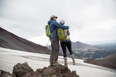 在美国俄勒冈州本德南修女火山顶峰上站着一对年轻夫妇背景图片