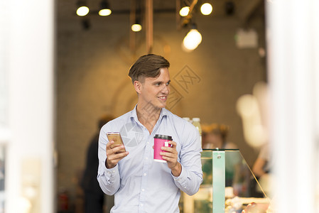 使用智能手机的带外送咖啡男人图片