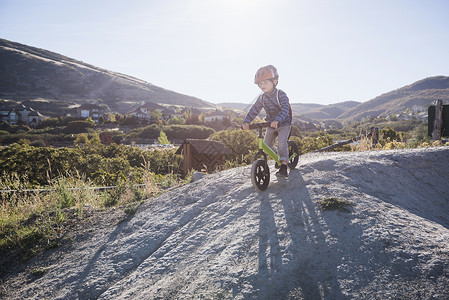 山坡上骑平衡自行车的男孩图片
