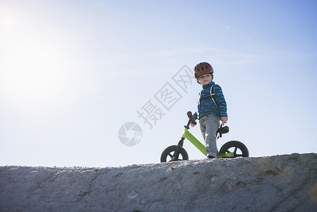 目光平衡山坡上骑平衡自行车的男孩背景