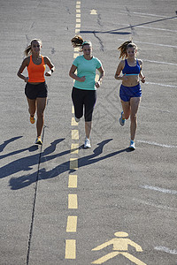 三名年轻女跑在停车场图片