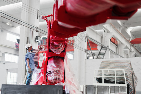 工人在工厂带防护面具喷洒红色起重机生产线高清图片素材