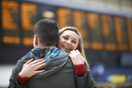 异地恋情侣在火车站相拥幸福笑容图片