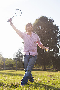 在日光公园玩羽毛球时喝酒的年轻人图片