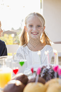 快乐女孩的肖像生日蛋糕在庭院桌上图片
