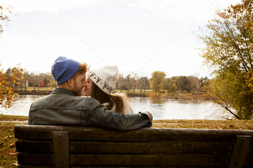 在公园湖边长椅上的青年夫妇图片