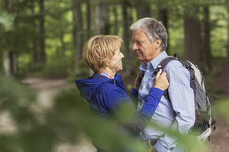 在森林中整理背带的中年夫妇积极的生活方式高清图片素材