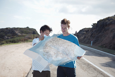 年轻人站在路上看地图图片