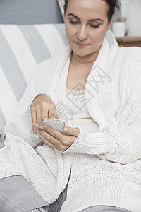 妇女在家里休息使用智能手机图片
