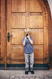 用智能手机拍照的男孩图片