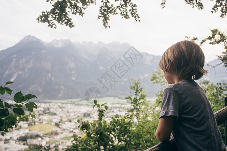 男孩仰望山脉背景图片