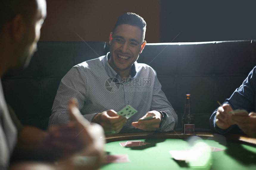 在酒吧牌桌上玩扑克牌的人图片