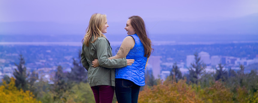 两个年轻女站在山坡上手对微笑着图片