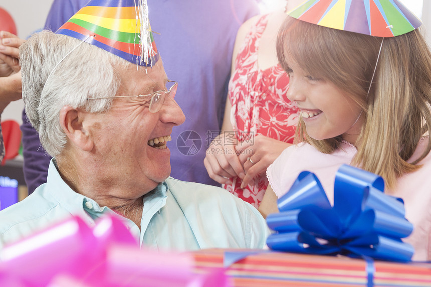 祖父和孙女戴着生日帽面对着微笑图片