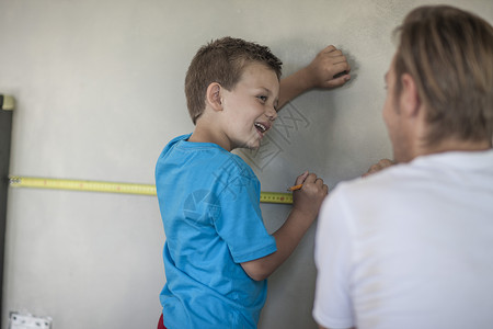 建筑工和儿子测量墙壁图片