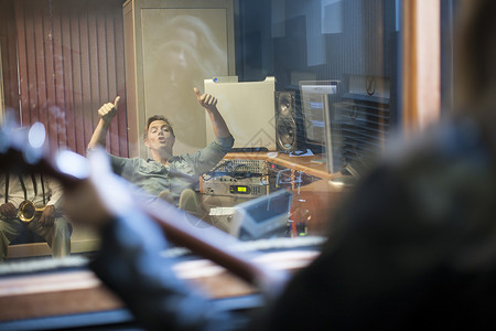 音乐制作人通过工室窗口与音乐家沟通图片