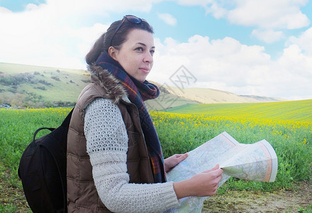 美之地图素材站在田野中拿着地图的年轻女士背景
