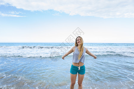 多米尼加勒比海滩上张开双臂的年轻美女图片