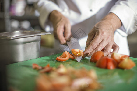 餐桌上切西红柿的厨师图片