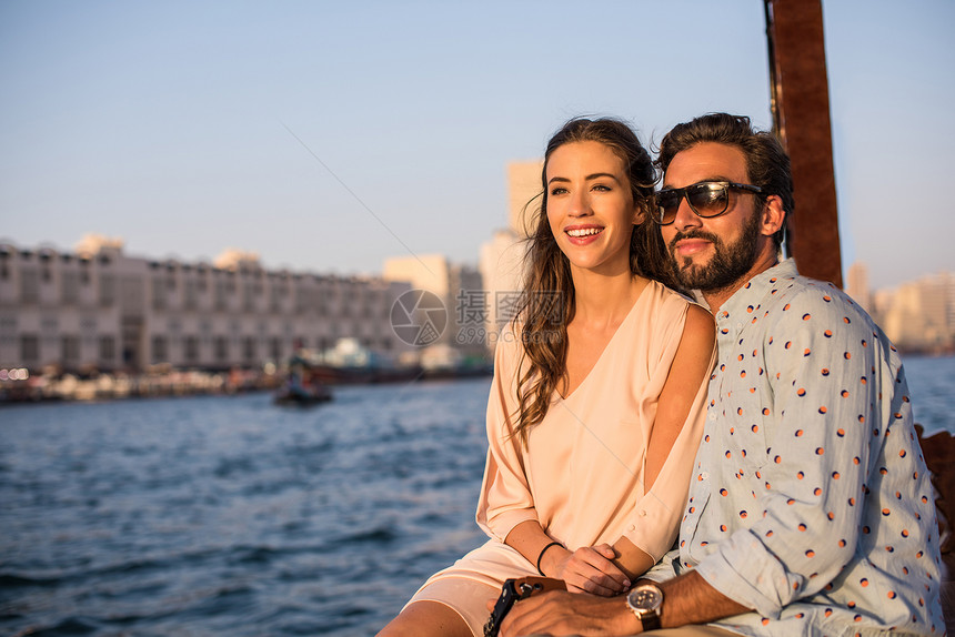 在阿拉伯联合酋长国迪拜码头的船上看风景的夫妇图片