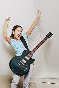 女孩吉他张嘴手臂在胜利中举起图片