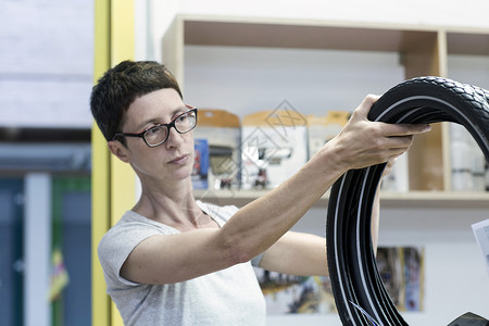工作间检查自行车轮胎的妇女图片