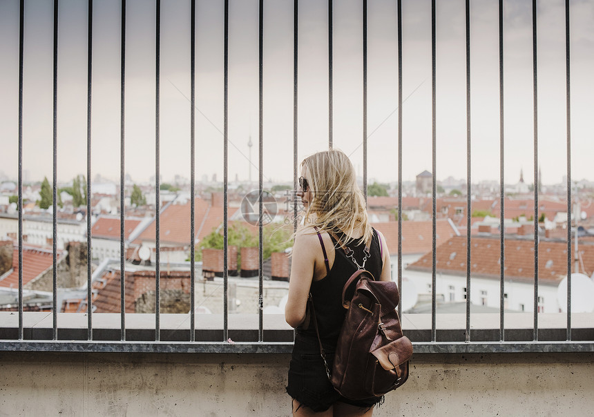 年轻女透过栏杆仰望屋顶的风景图片