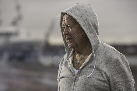 穿连帽外套的男子看向一侧背景图片