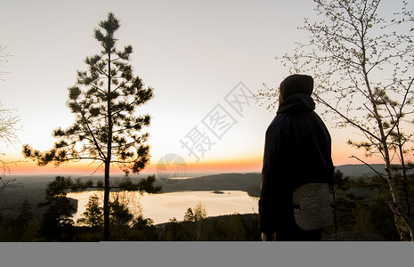 享受日落时湖景观的旅游者图片