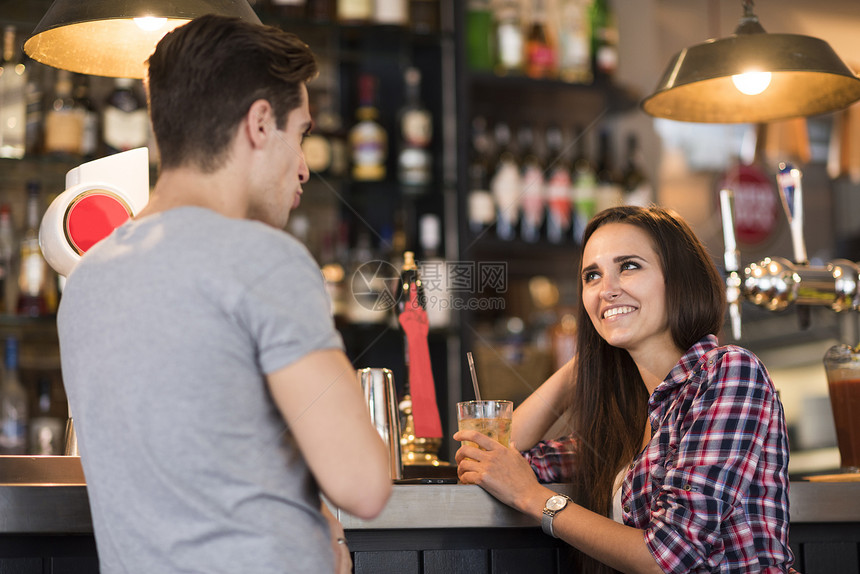 在酒吧聊天的年轻夫妇图片