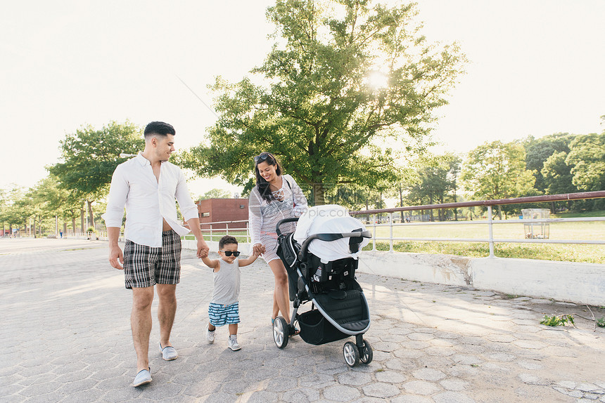 美国纽约布朗克斯PelhamBay公园与幼儿男孩和推椅一起行走的父母图片